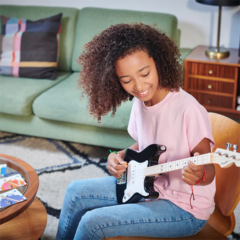 girl playing Fender X Loog Guitar