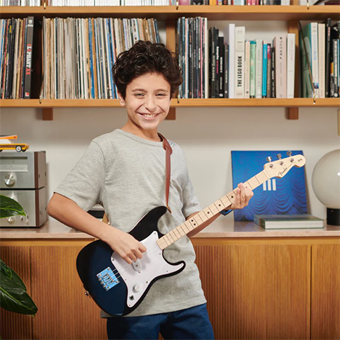 Boy playing Fender X Loog guitar
