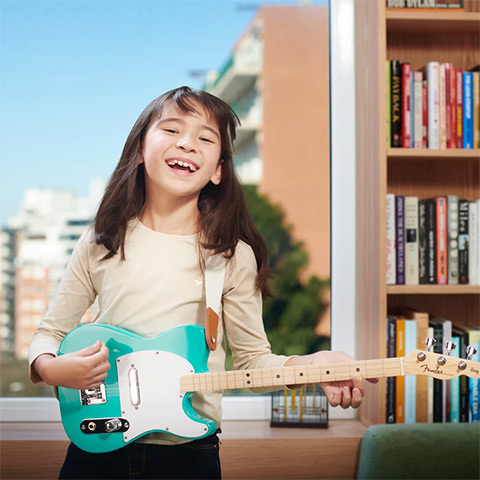 Girl playing Fender X Loog guitar