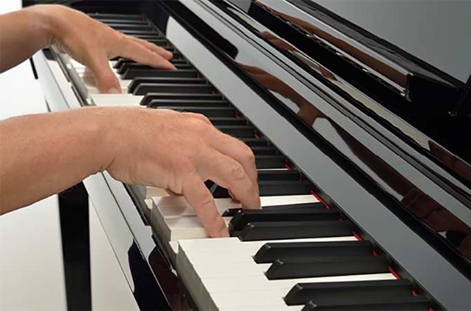 Close up of hands playing Clavinova piano