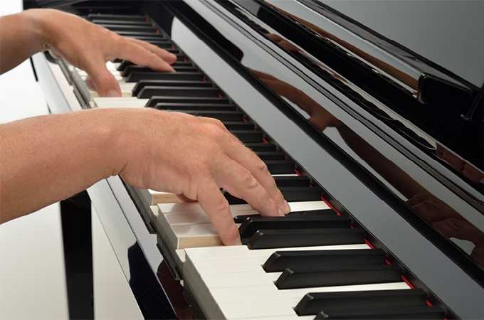 Close up of hands playing Clavinova piano
