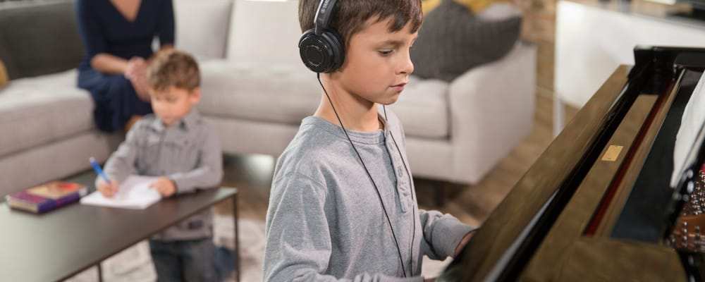 Child with headphones practicing piano acoustic