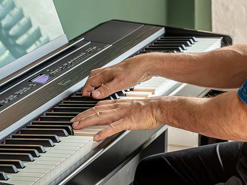 Hands playing P525 Digital Piano