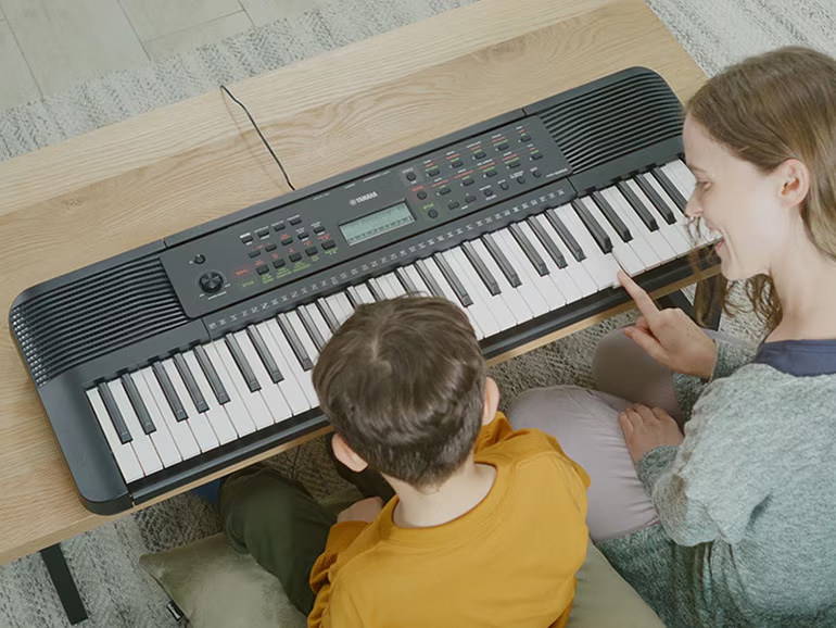 adjult and child playing keyboard together