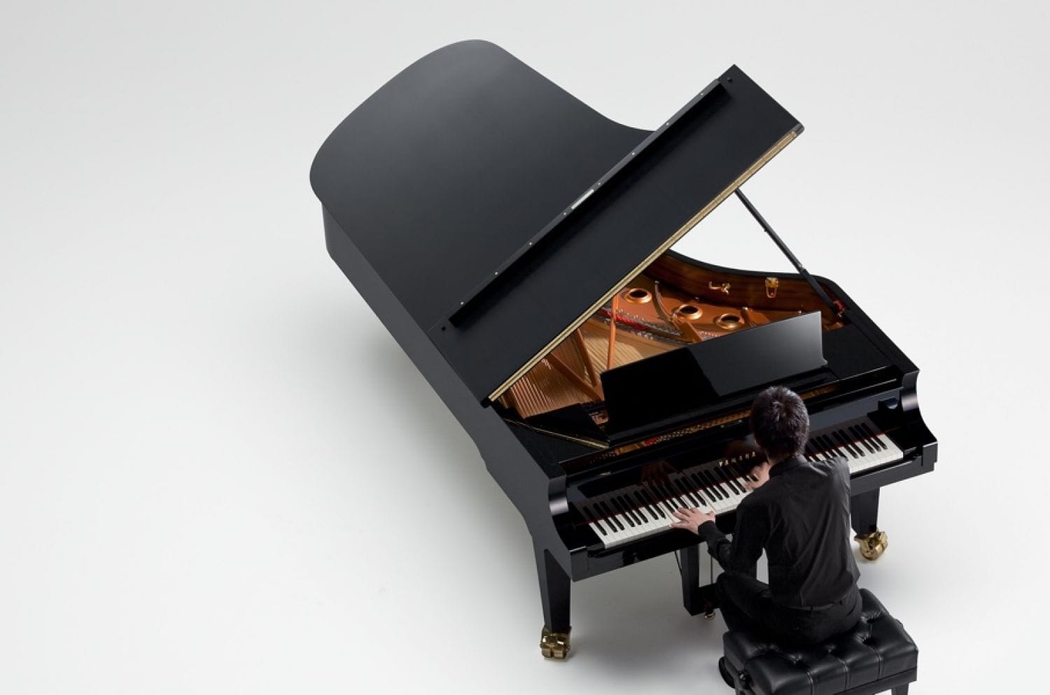 Arial view of person playing Yamaha CF piano in a white room