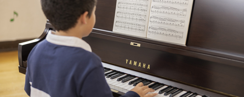 Child playing Yamaha P22 Upright Acoustic Piano